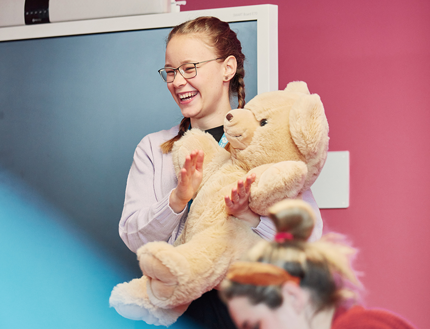 Student holding a giant teddy bear