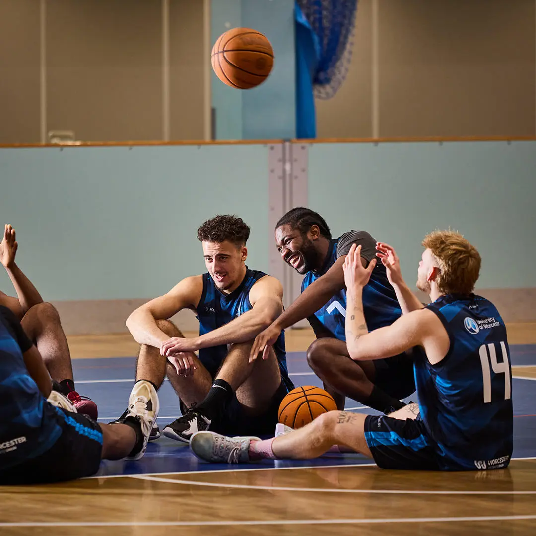 men sat around with a basketball