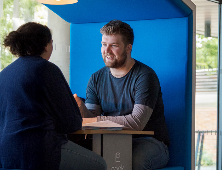 Two students deep in discussion in a study nook