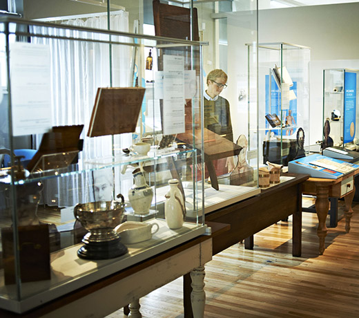 Student looking into glass cases of historic medical equipment