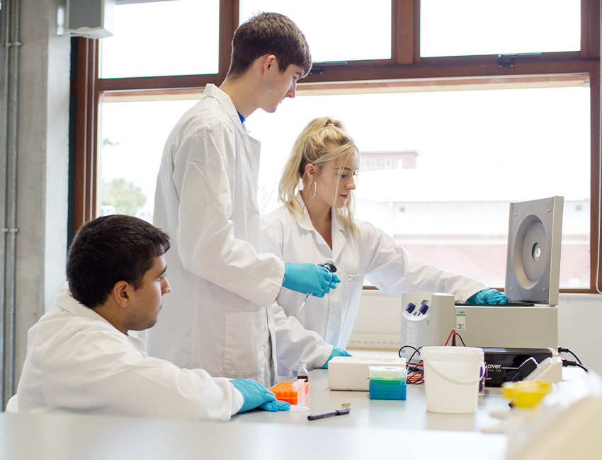 Three science students working in a lab