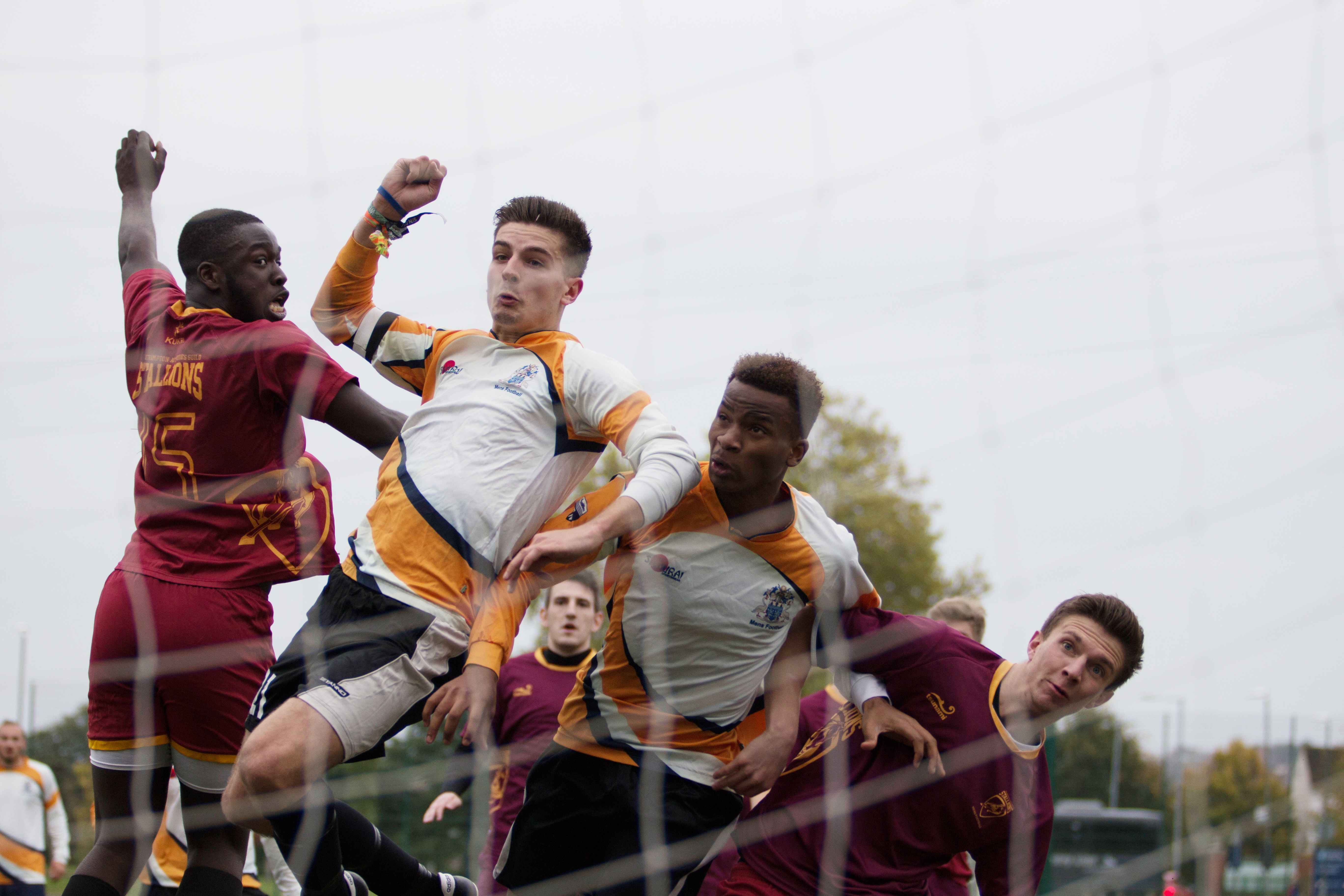 A group of footballers leaping for the ball