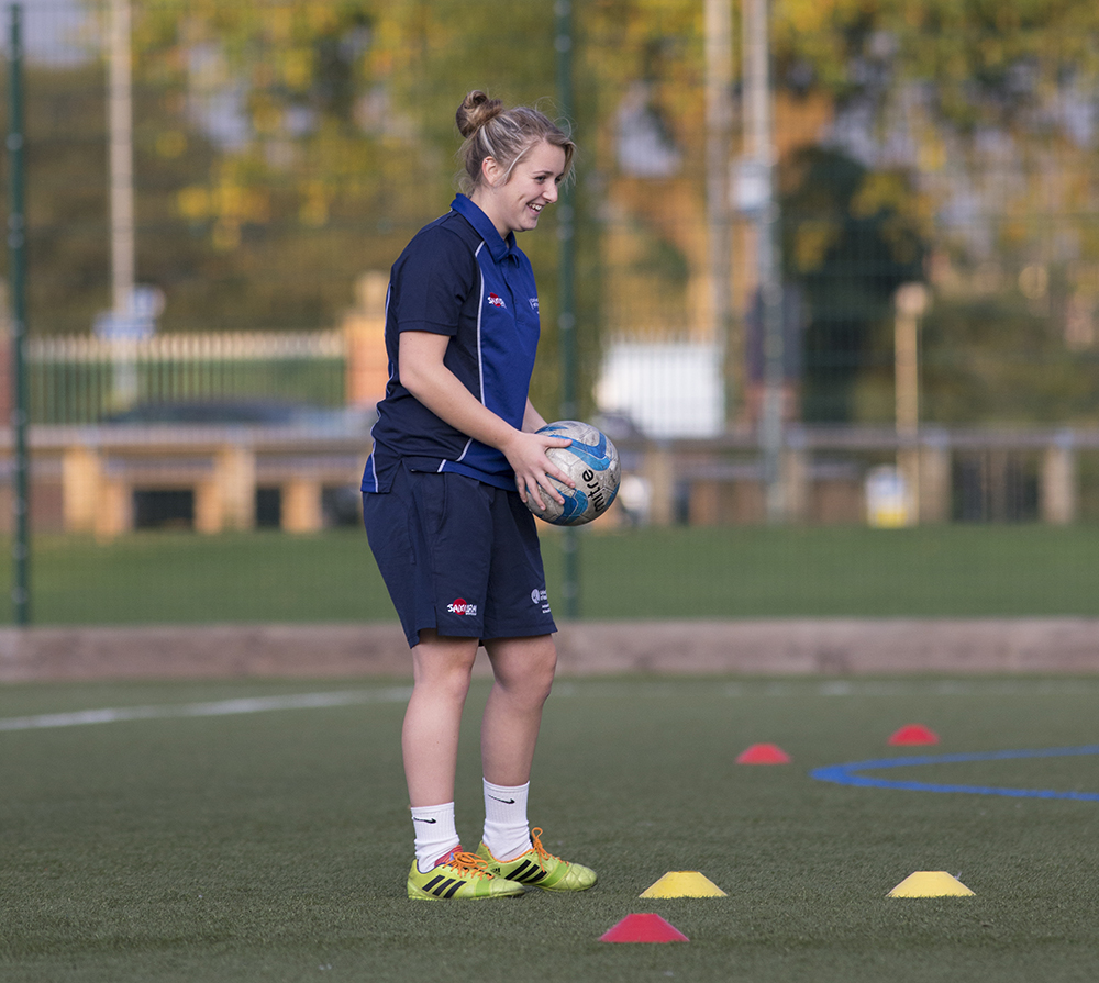 A football student preparing a coaching session on astroturf pitch