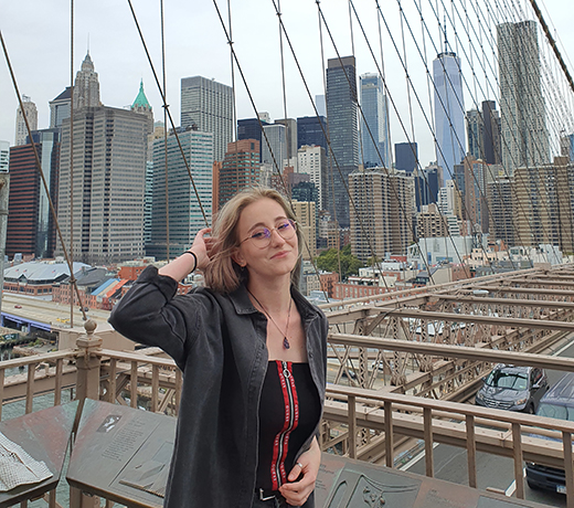 A Study Abroad student posing in front of the Brooklyn Bridge