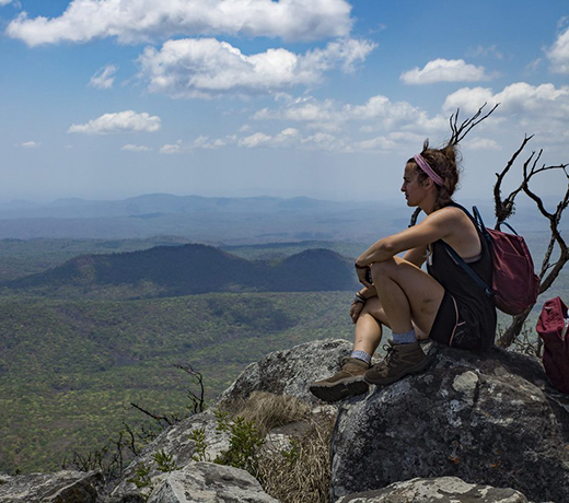 Student sitting on a rock, looking out at Malawi