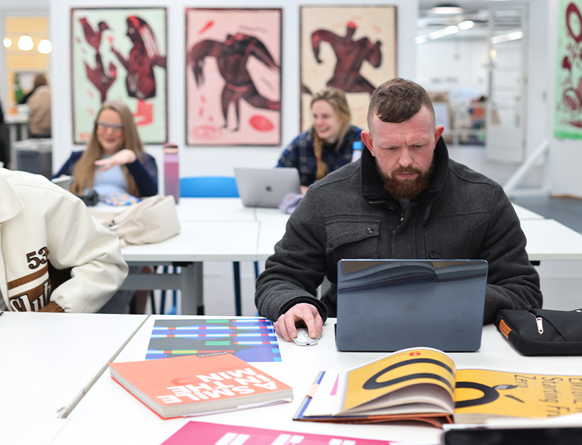 Graphic Design students working on laptops during a class