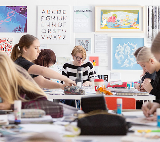 A large group of arts students working around a large table