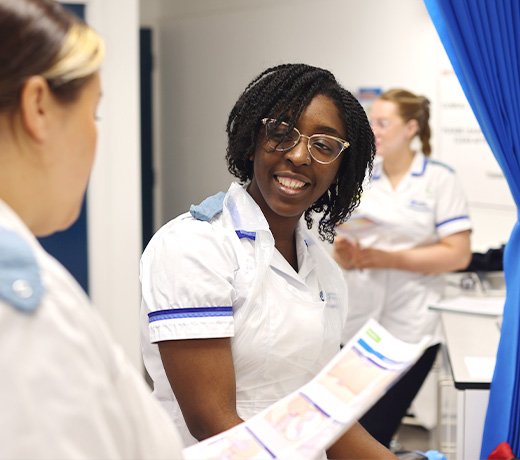 A student nurse smiling at another student