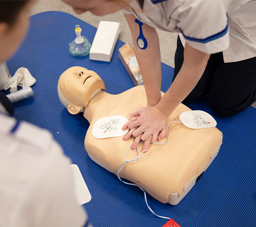 A student nurse practicing CPR on a manakin