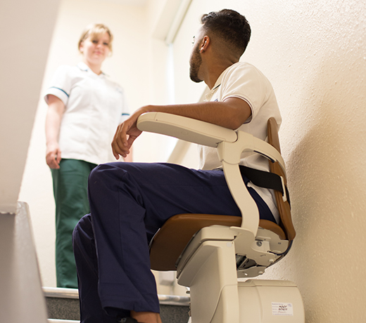 A student using the stair lift in Ability House