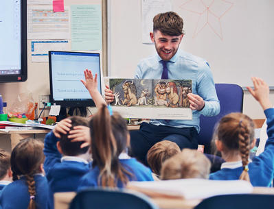 A teacher is showing his class the children's book 'Where the wild things are'