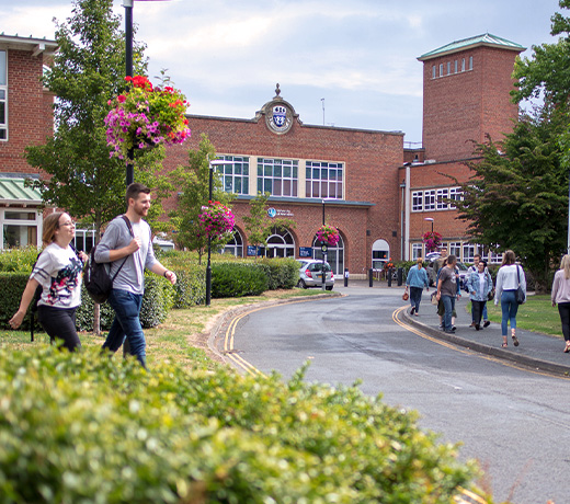 Students walking along the road and path to the Edward Elgar building on St John's Campus