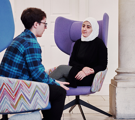 Two students seated and having a discussion