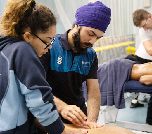 Two students giving a patient a sports massage