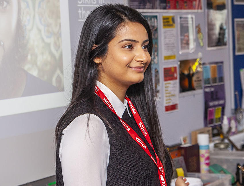 A smiling student is teaching a class