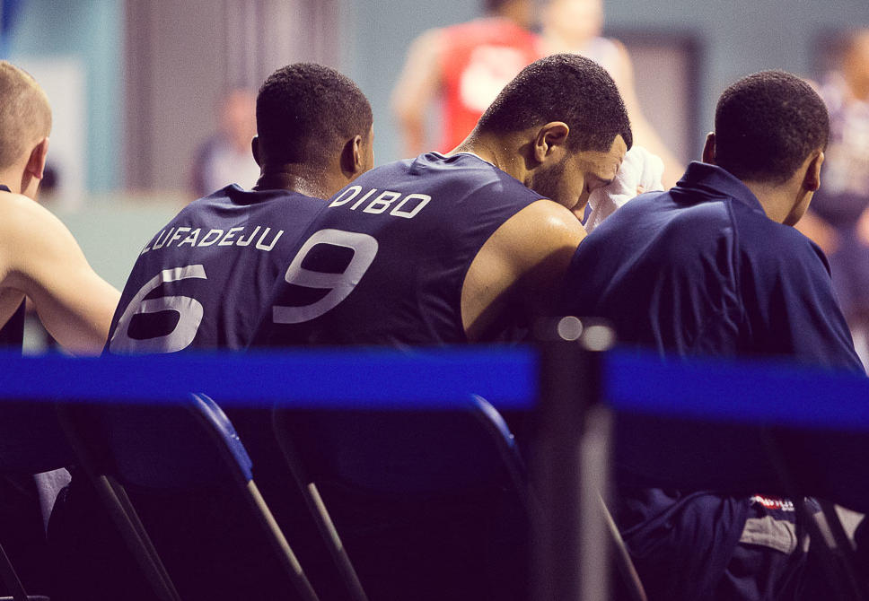 Basketball team sat on bench.