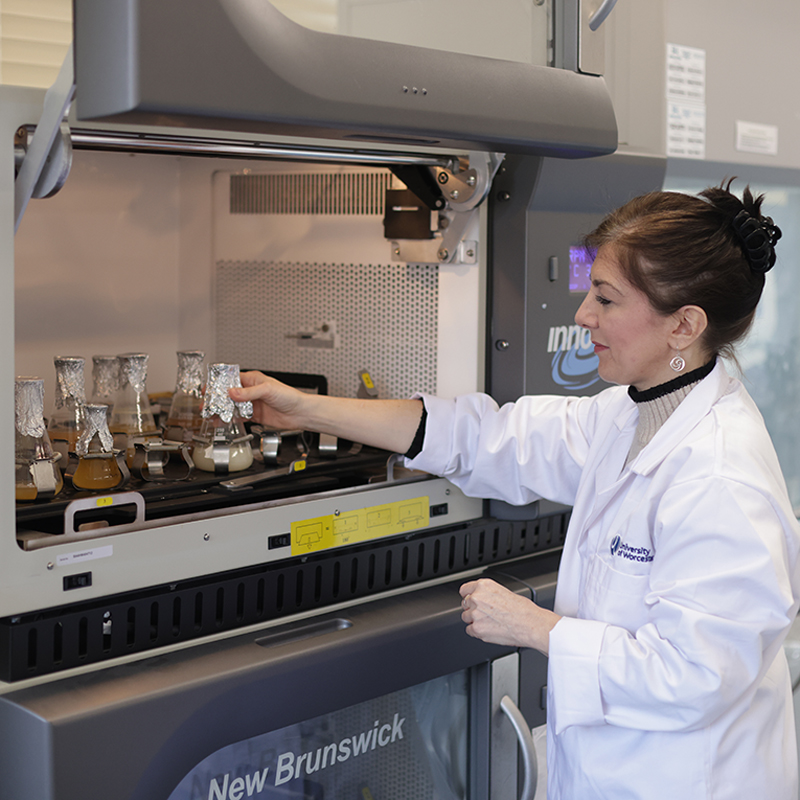 Women in lab coat standing in front of machine