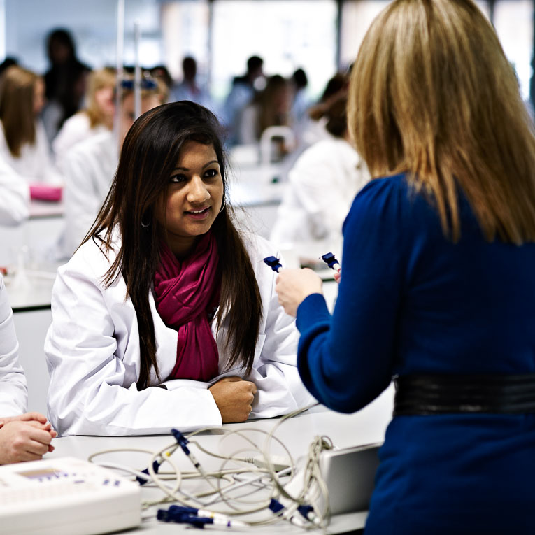 Lecturer demonstrating equipment to student in teaching lab