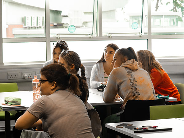 Students sitting around tables learning