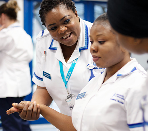 A student nurse supporting another student by the arm