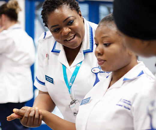 A student nurse supporting another student by the arm