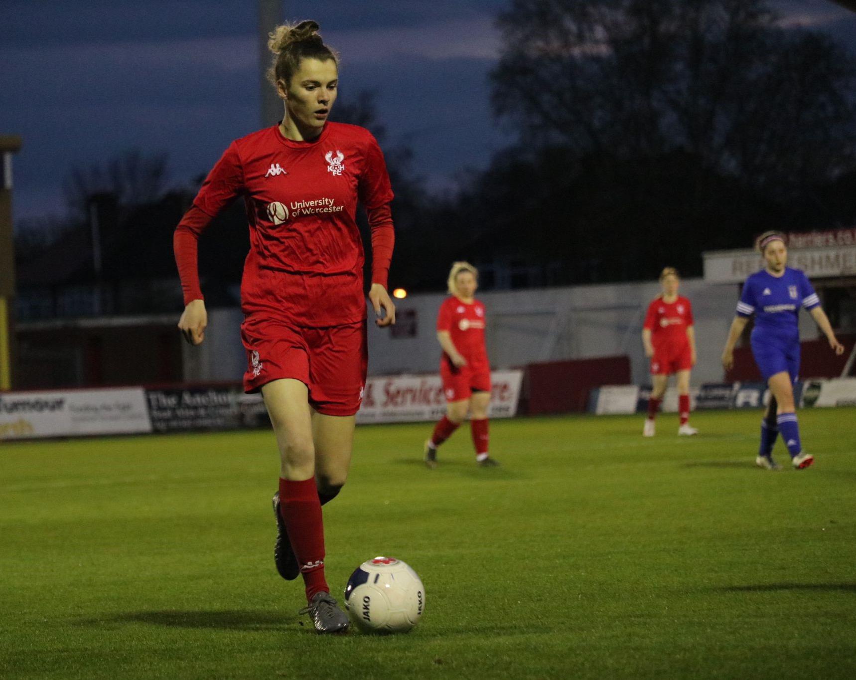 Football player wearing a red kit with University of Worcester logo