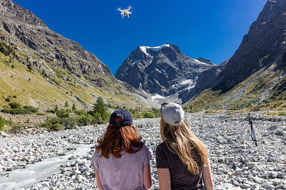 two students looking at a drone