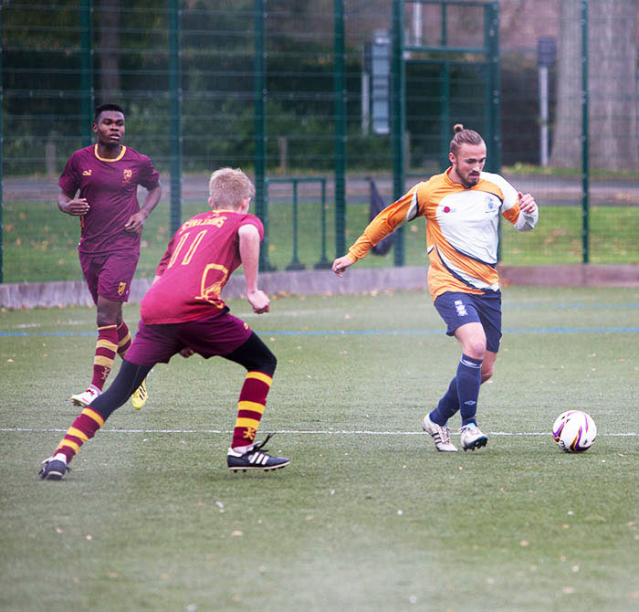 three men playing football