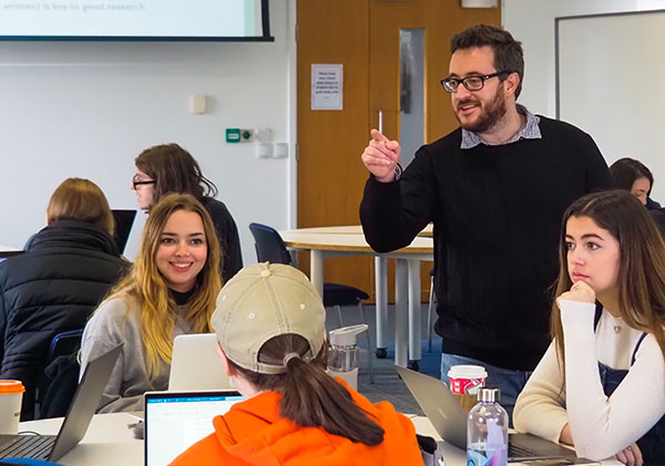 a lecturer is talking to several students in an animated lecture