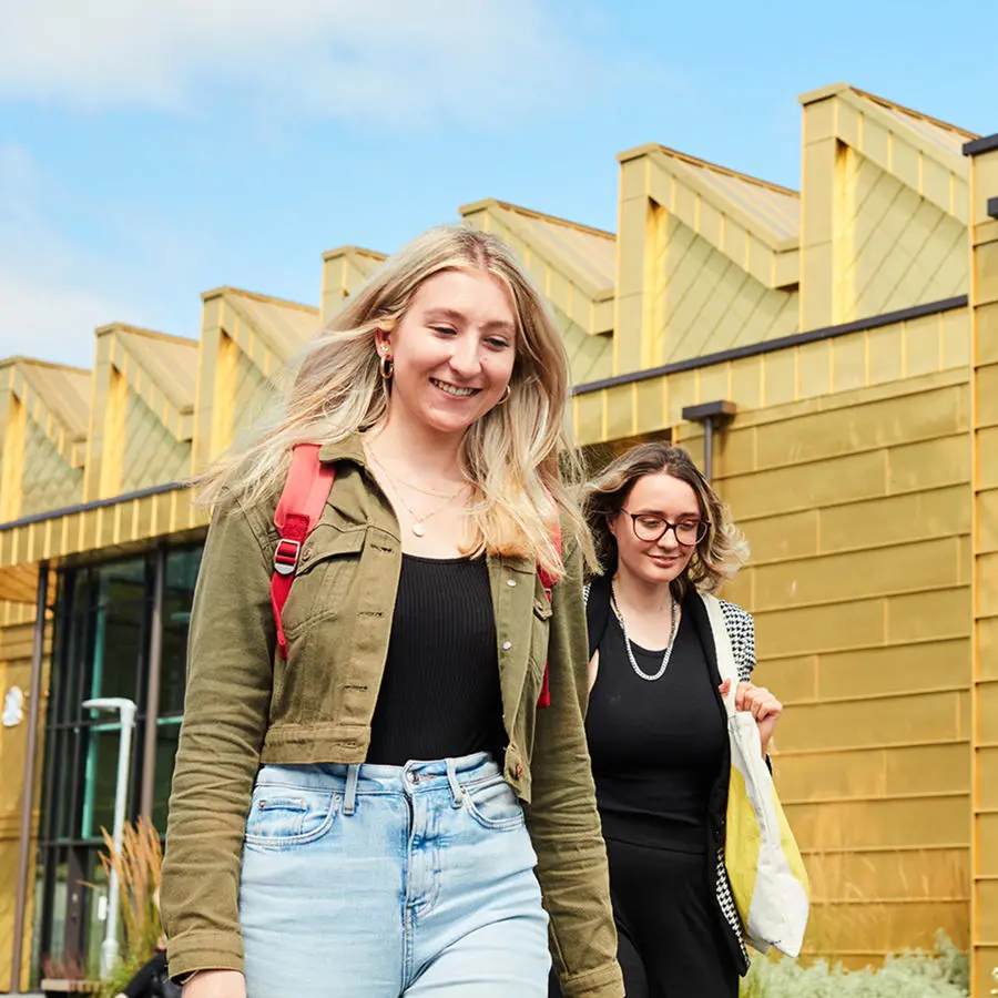 Two students walking from the Medical School building