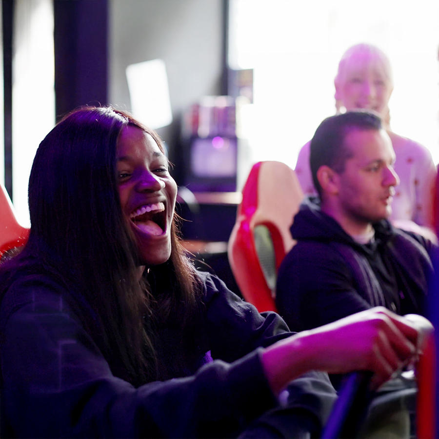 Students playing a racing game in an arcade