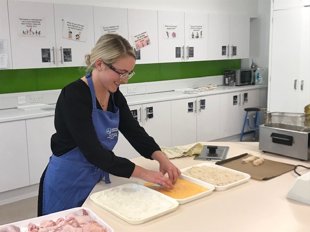 Student preparing ingredients in a kitchen