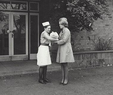 A mother and baby are talking to a nurse.